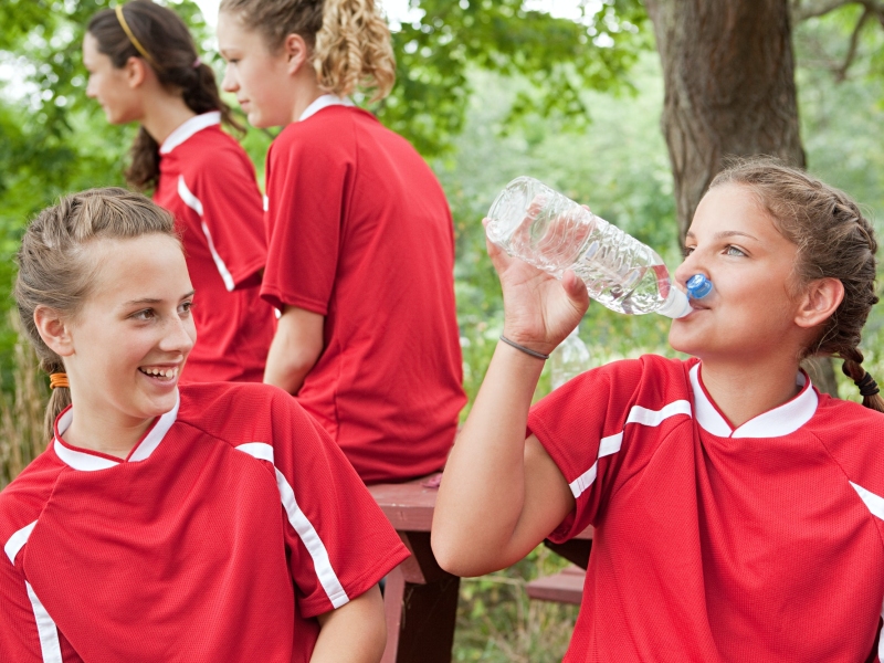 Girl soccer players drinking water